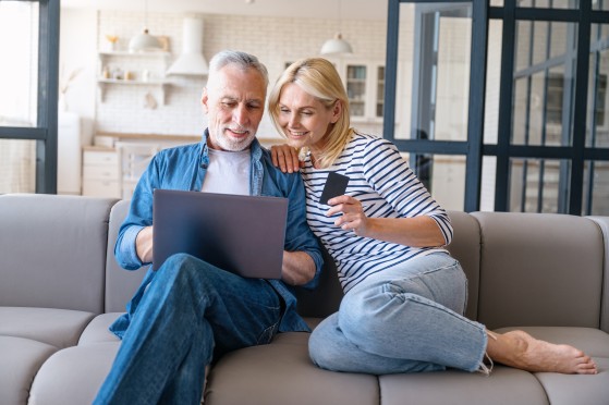 älteres Paar auf Sofa mit Laptop